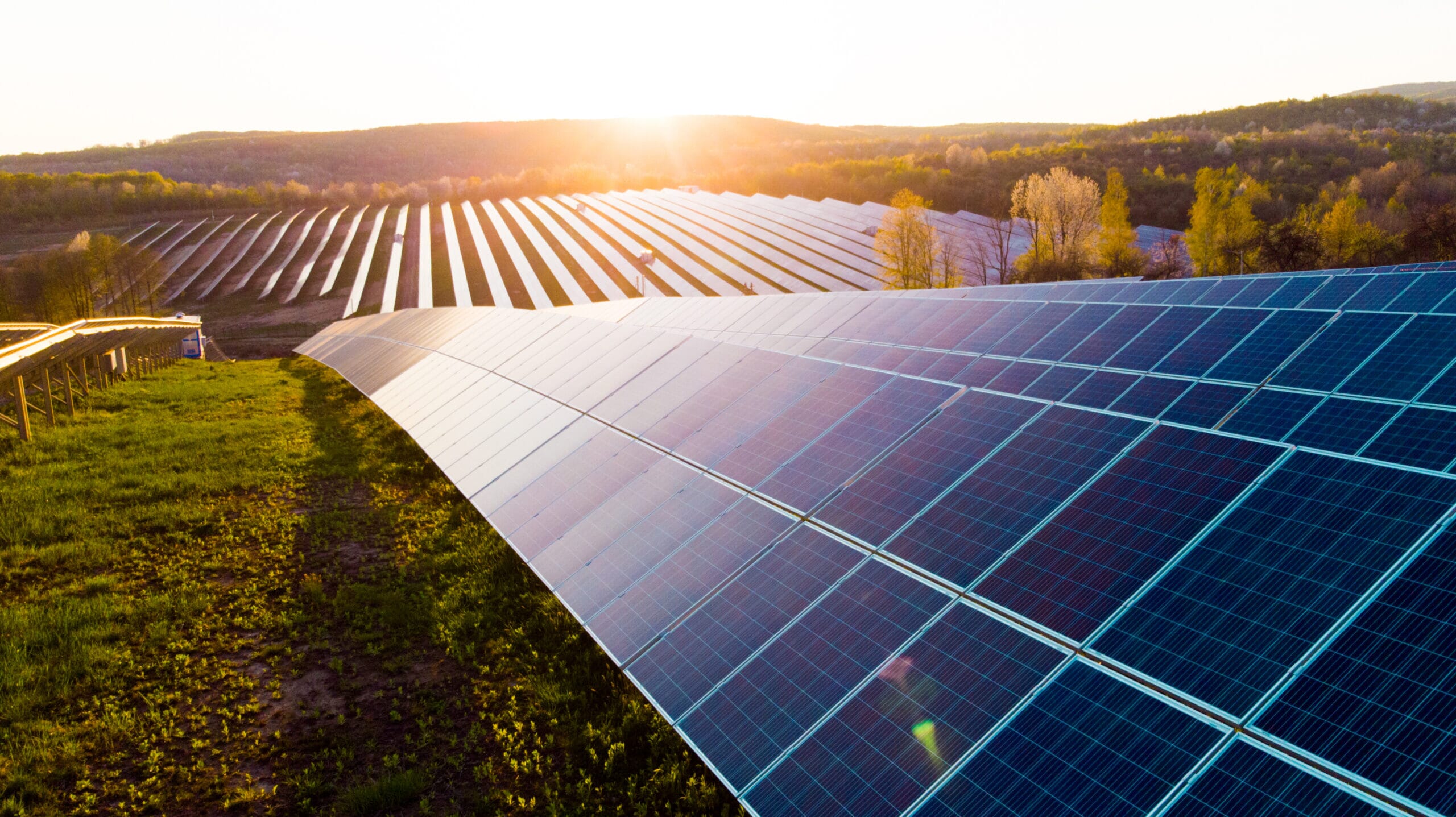 Solar panels in a field at sunset, representing the benefits of renewable energy developments for landowners